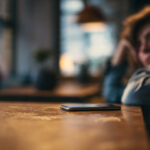 Woman looking peaceful with phone face down—taking a break from dating apps to cure dating fatigue.